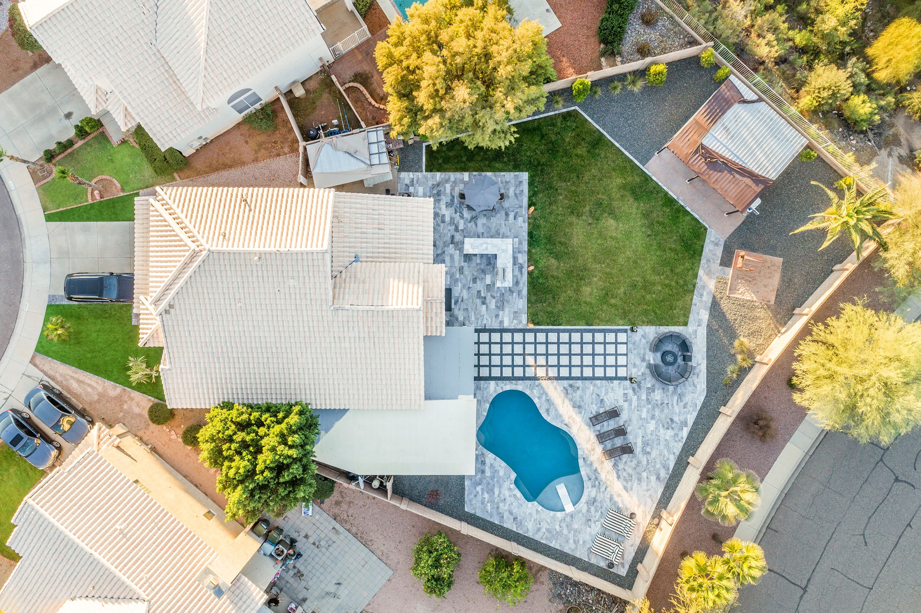 Aerial view of Arizona backyard with rectangular pool, travertine deck, and lush turf